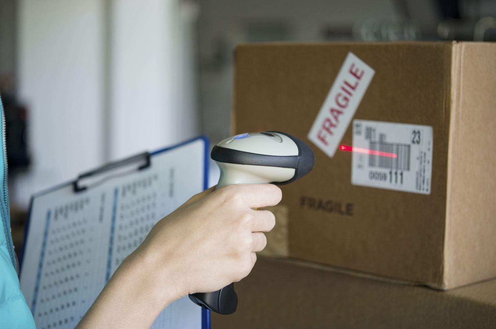Een medewerker scant met een barcodescanner het label op een doos